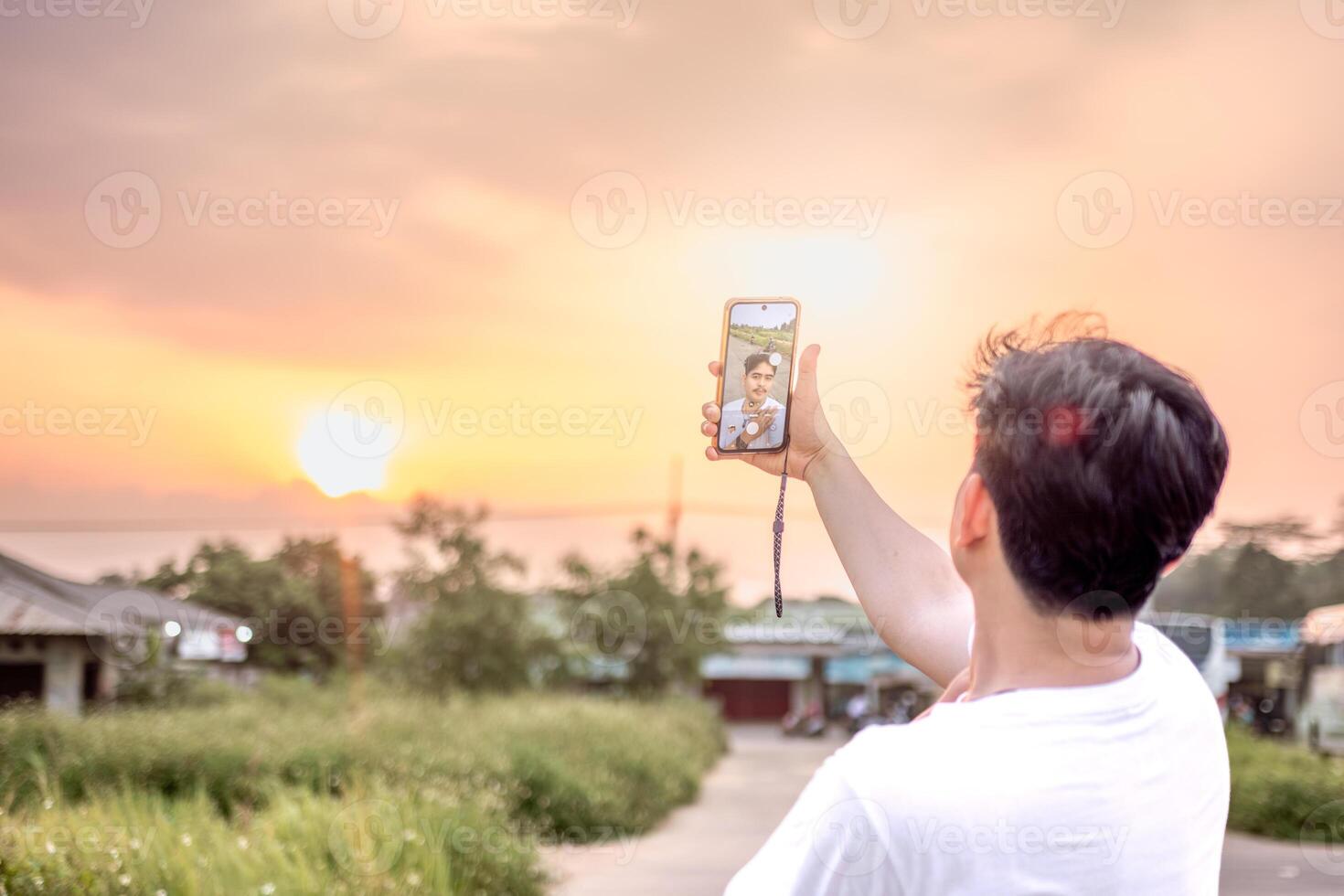 a man who is taking photos of himself and nature in various styles. the man has his back to the camera. set on a sunny afternoon in nature.