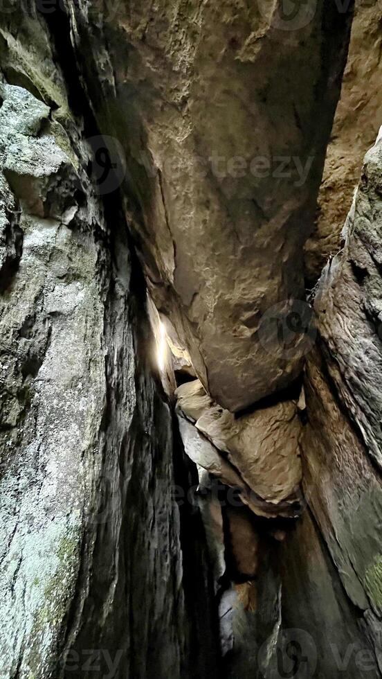 Sun rays pass through the stones in a cave. Poland photo