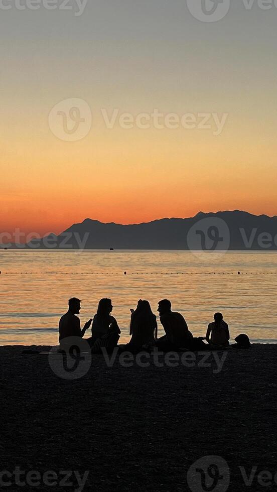 Sunset on the beach, people watching the sunset on the Adriatic Sea in Croatia. Silhouette photography photo