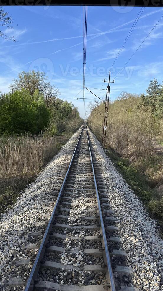 View of the railway tracks from the moving last car of a train. photo