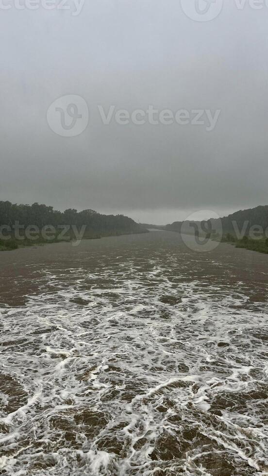 Flowing stream of dirty water in the river, river filled with dirty water after flood. Oder River, Poland photo