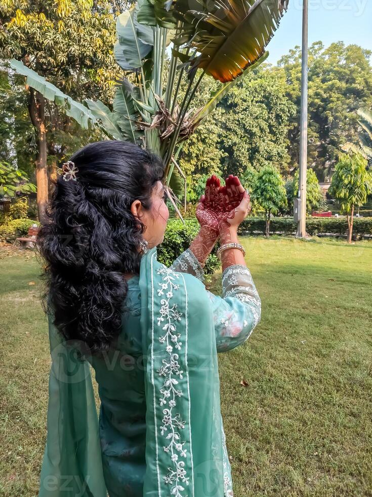 Beautiful woman dressed up as Indian tradition with henna mehndi design on her both hands to celebrate big festival of Karwa Chauth, Karwa Chauth celebrations by Indian woman for her husband photo