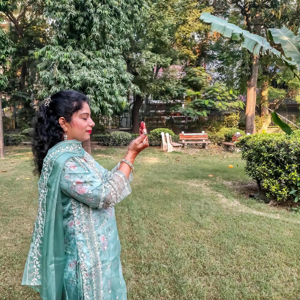 Beautiful woman dressed up as Indian tradition with henna mehndi design on her both hands to celebrate big festival of Karwa Chauth, Karwa Chauth celebrations by Indian woman for her husband photo