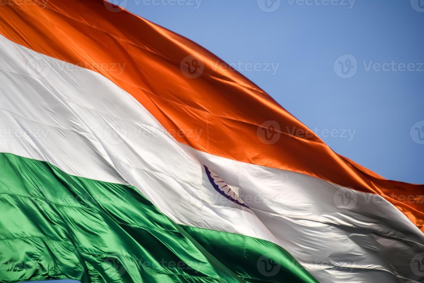 India flag flying high at Connaught Place with pride in blue sky, India flag fluttering, Indian Flag on Independence Day and Republic Day of India, tilt up shot, Waving Indian flag, Har Ghar Tiranga photo