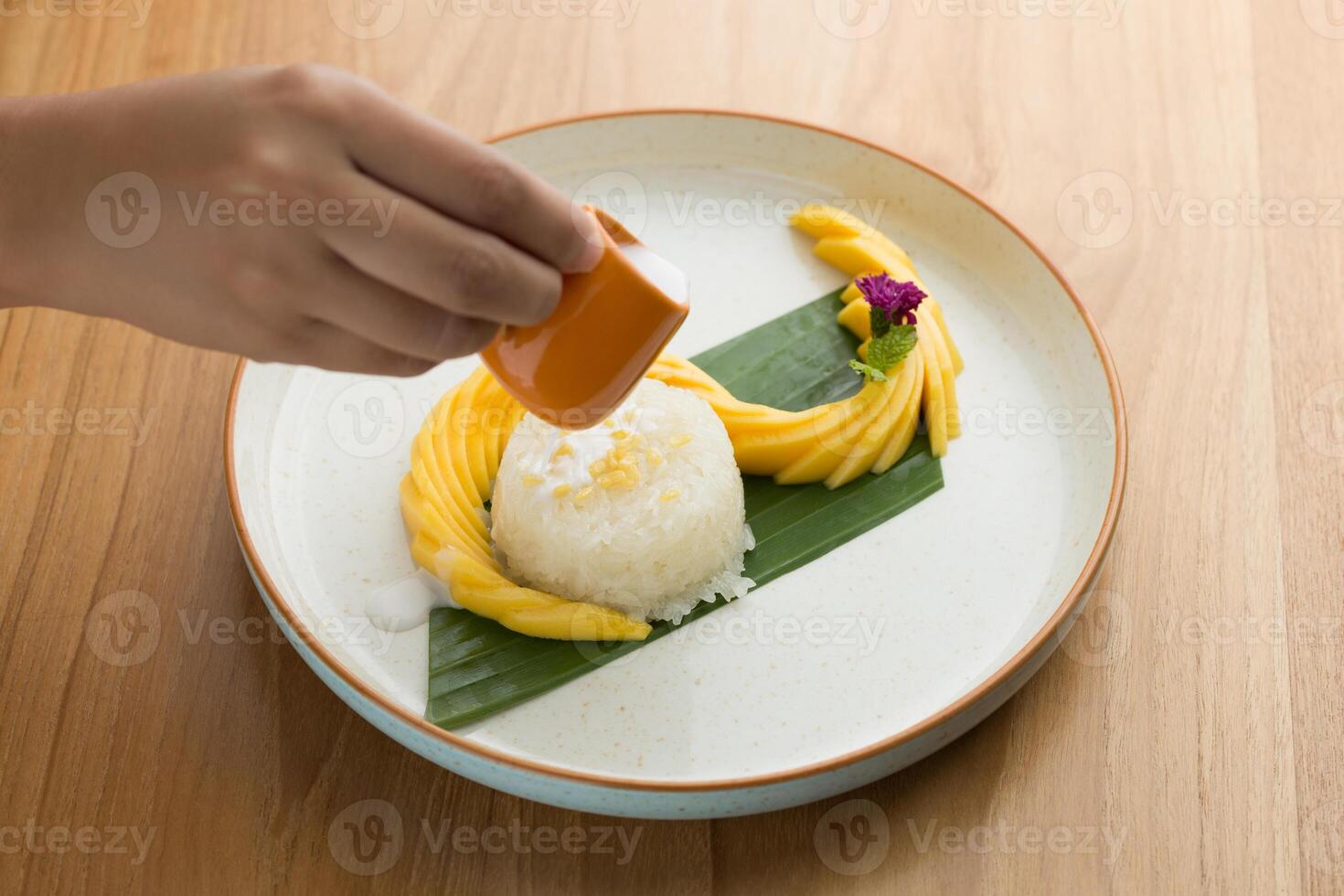 Mango sticky rice, featuring coconut milk as a key ingredient and topped with roasted mung beans for added crunchiness. photo