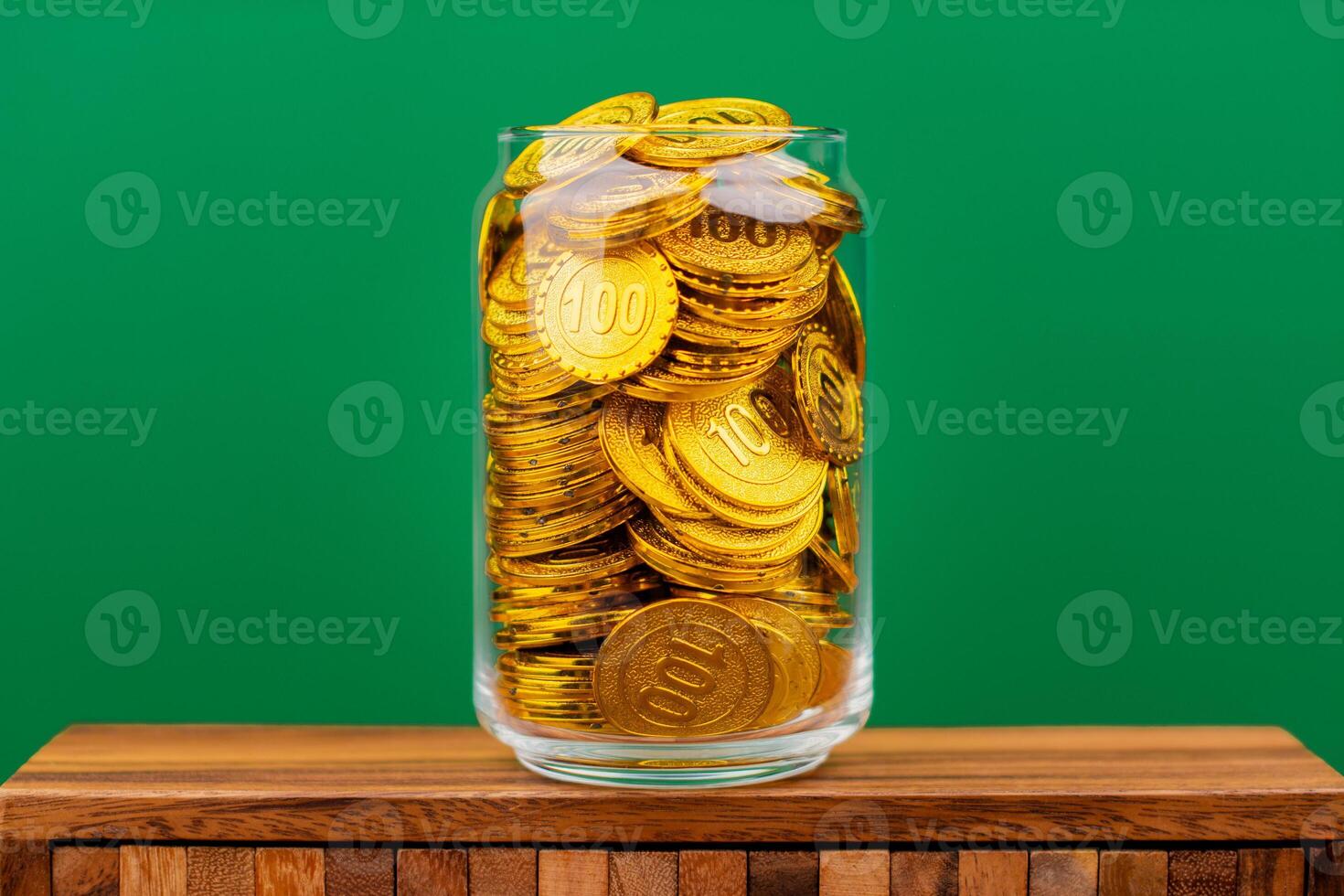Saving gold coins in glass jars and investing in gold, high value gold market, wealth and riches photo