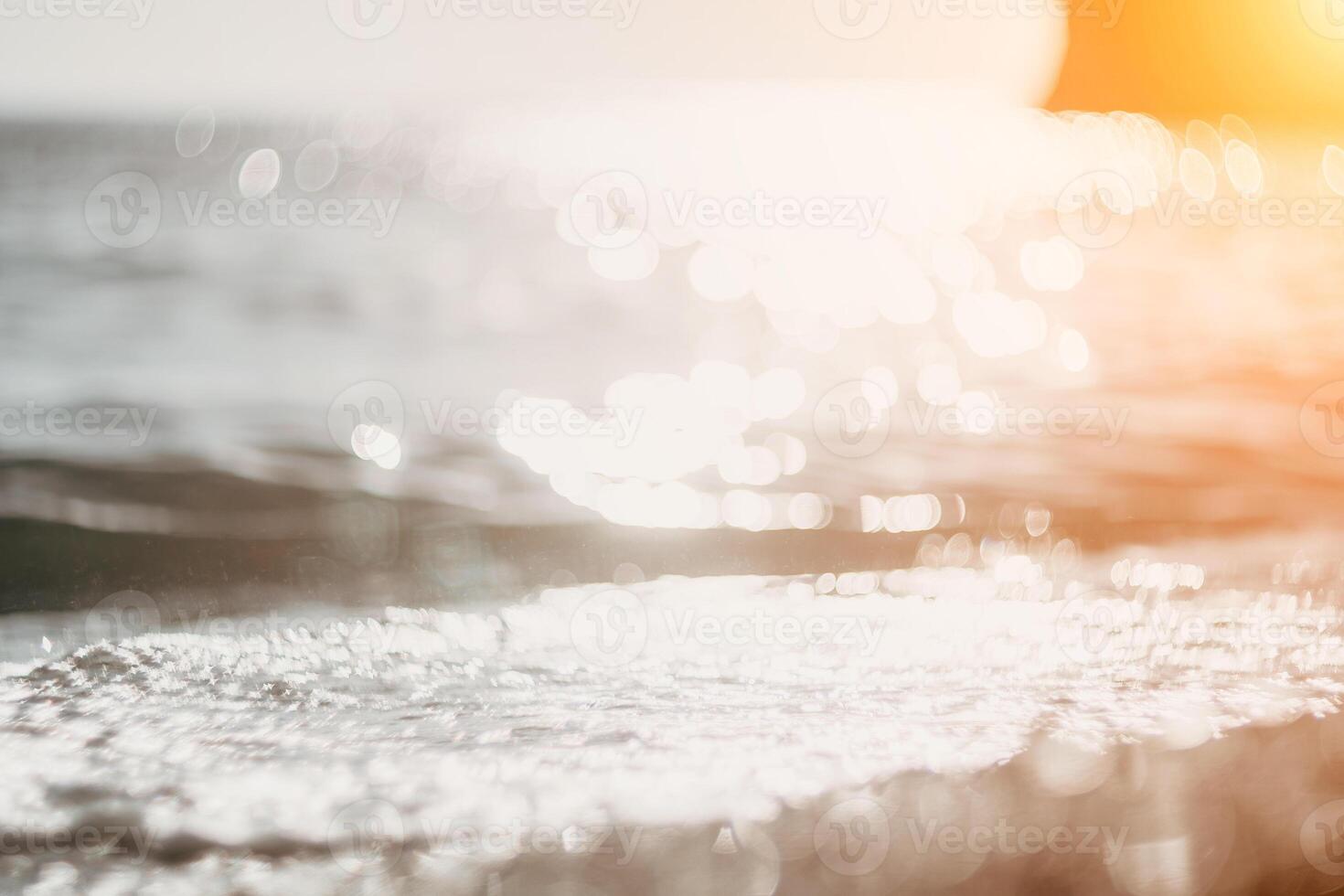 Abstract nature summer ocean sunset sea background. Small waves on water surface in motion blur with bokeh lights from sunrise. Holiday, vacation and recreational background concept. photo