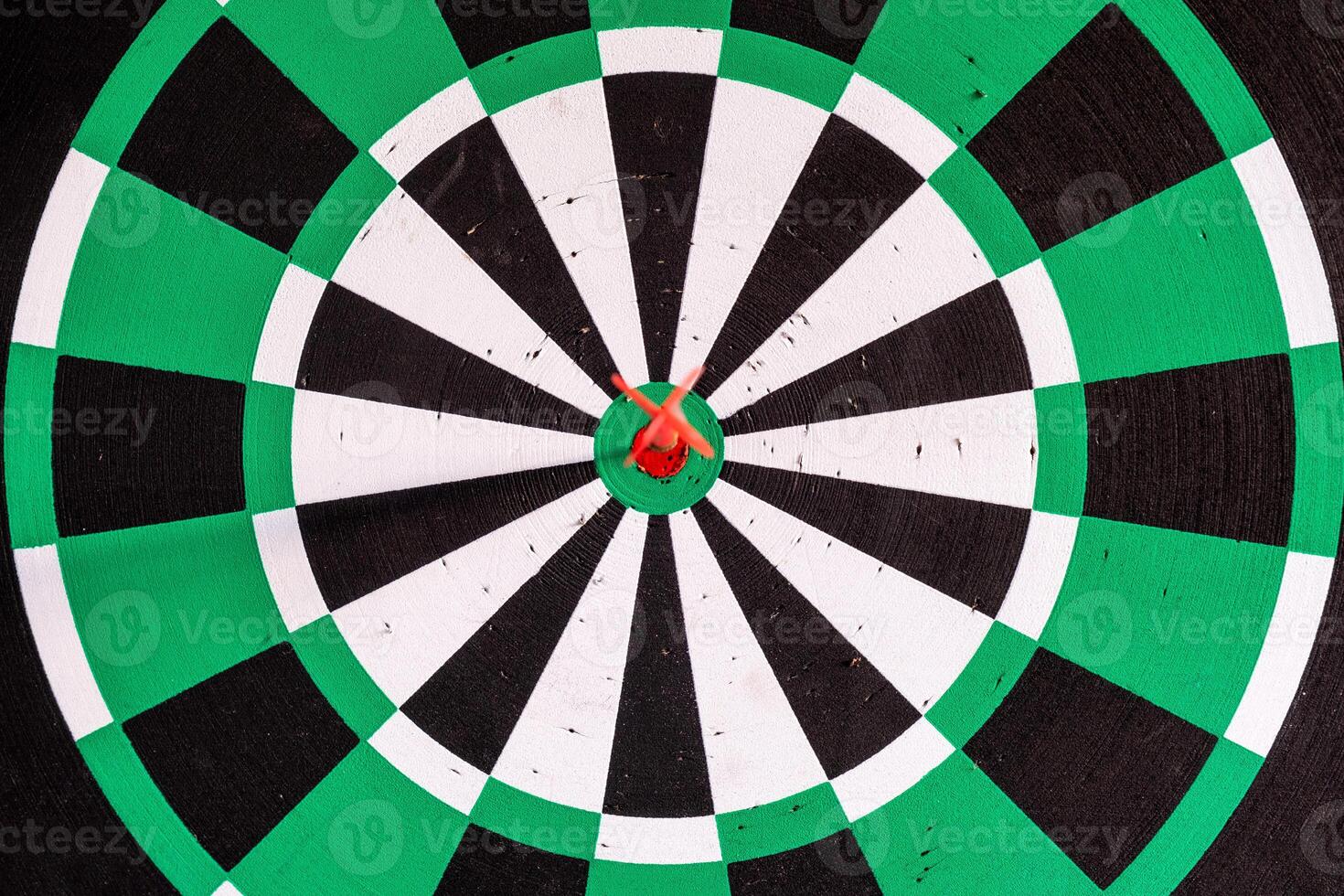 Dart arrow in bullseye target on dartboard photo