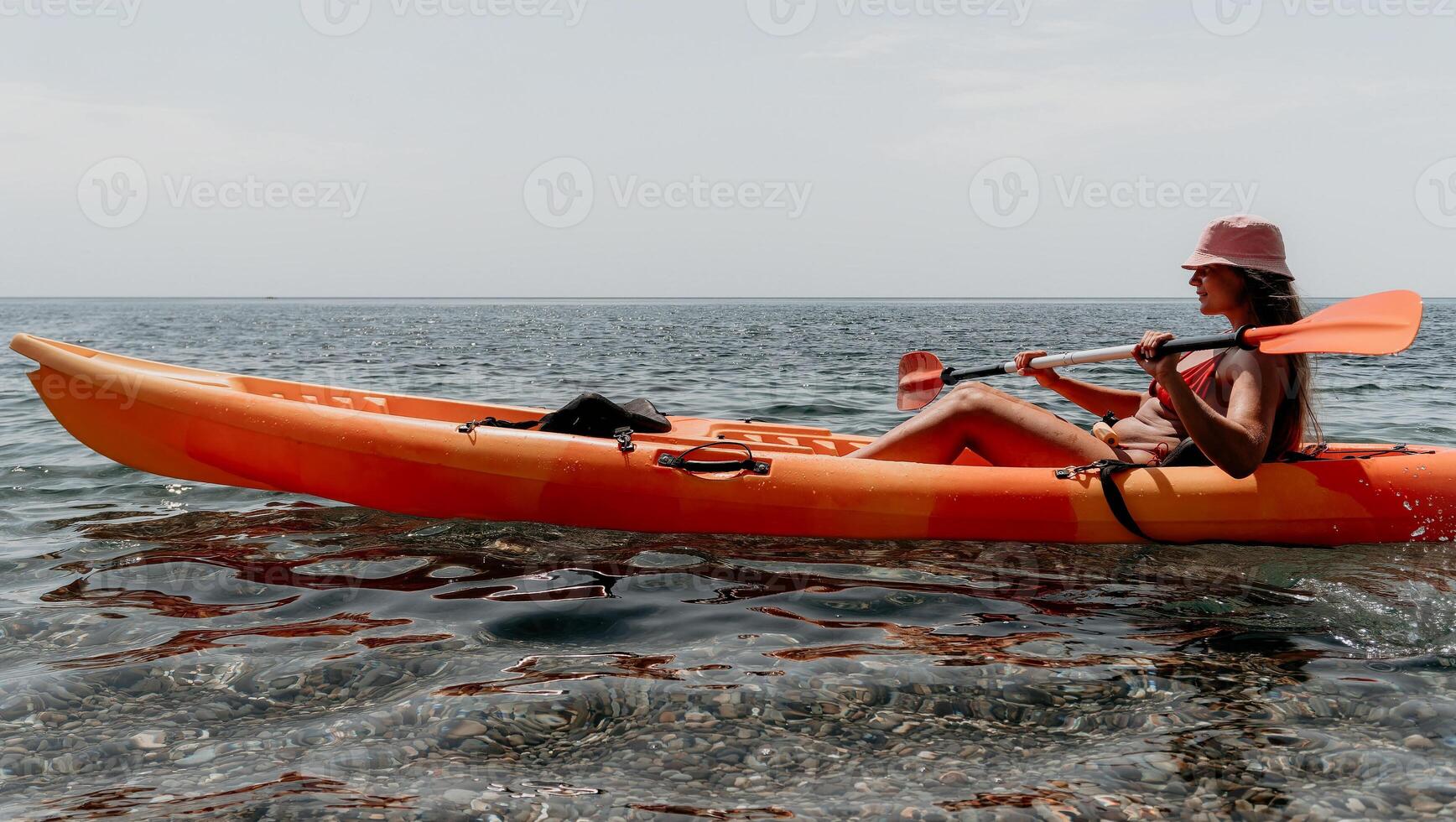 Kayaking, Beach, Ocean, Woman in kayak paddling on the beach, enjoying a day on the water. photo