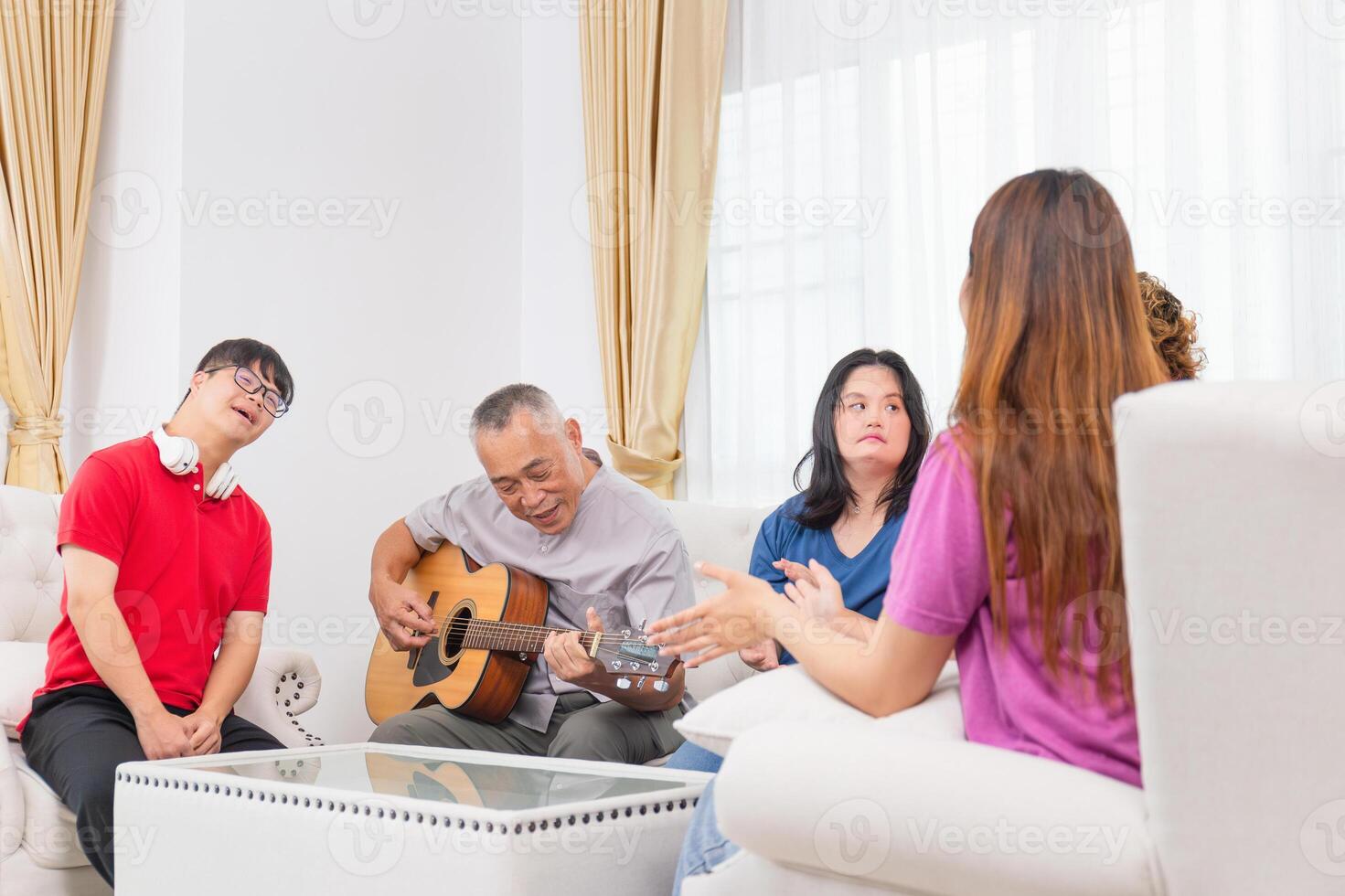 Senior man and grandchild having fun together while singing and playing the guitar in living room at home photo