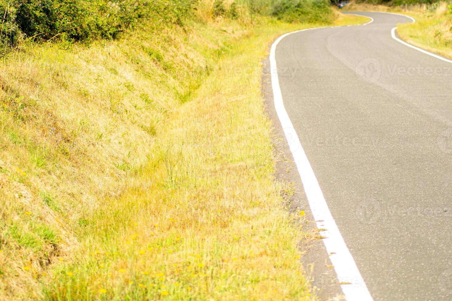 curve of a lonely road in galicia in summer, background of concept of road trip photo