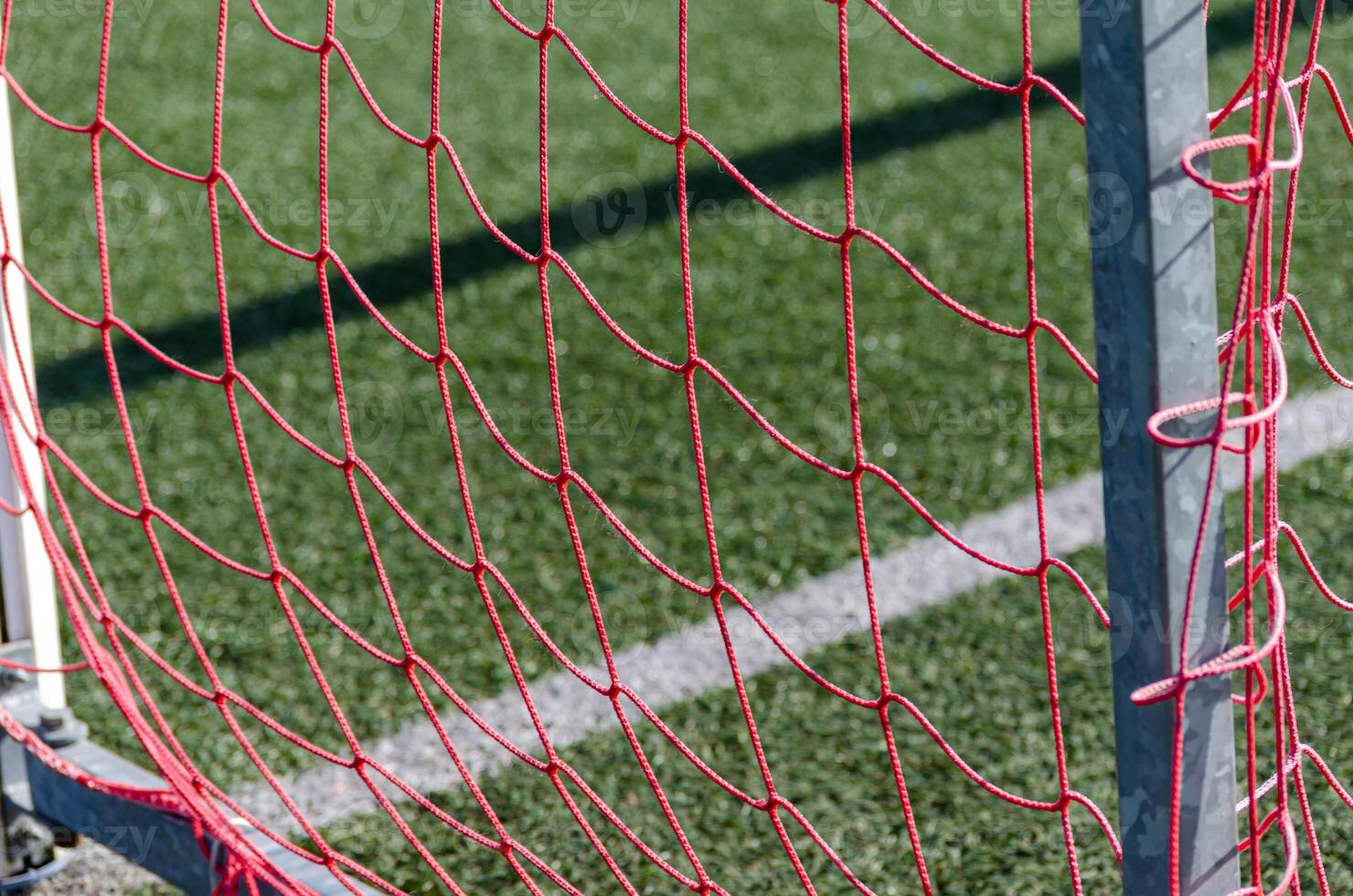 red netting of a football goal of an artificial turf field photo