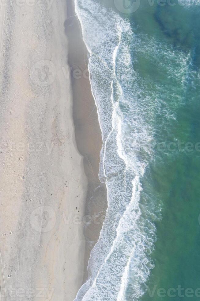 Beautiful white empty beach and sea waves seen from above. photo