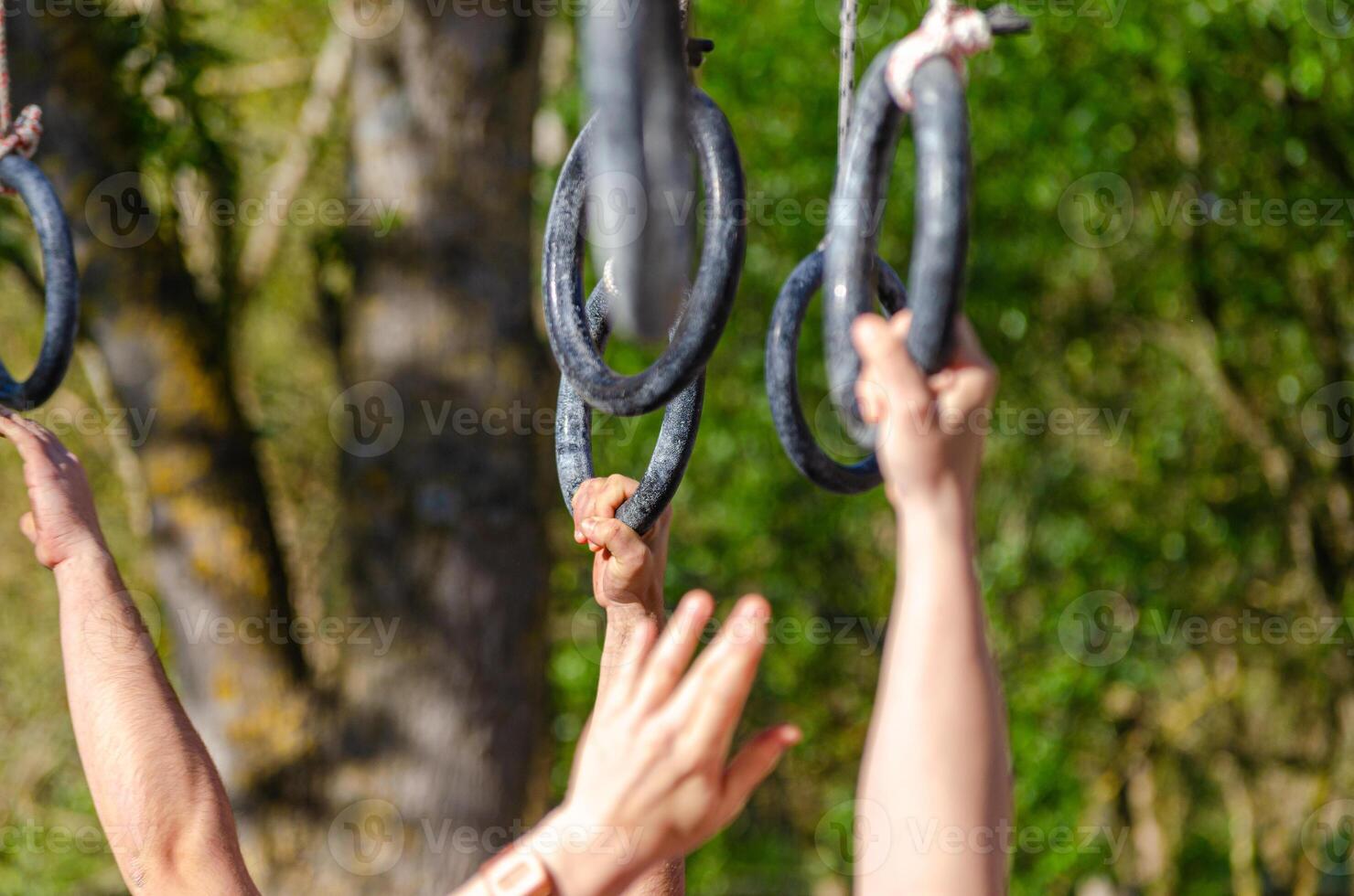 Hands grasp a rings at a hanging obstacle in an OCR obstacle course, ocr race course concept photo