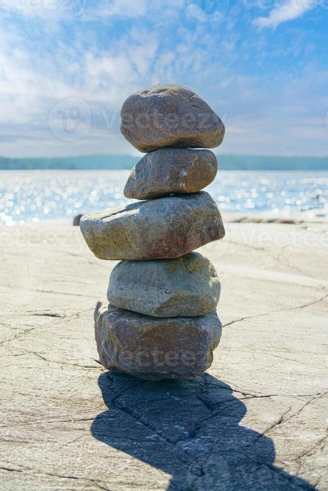 Stacked Rocks balancing, stacking with precision. Stone tower on the shore. Copy space photo