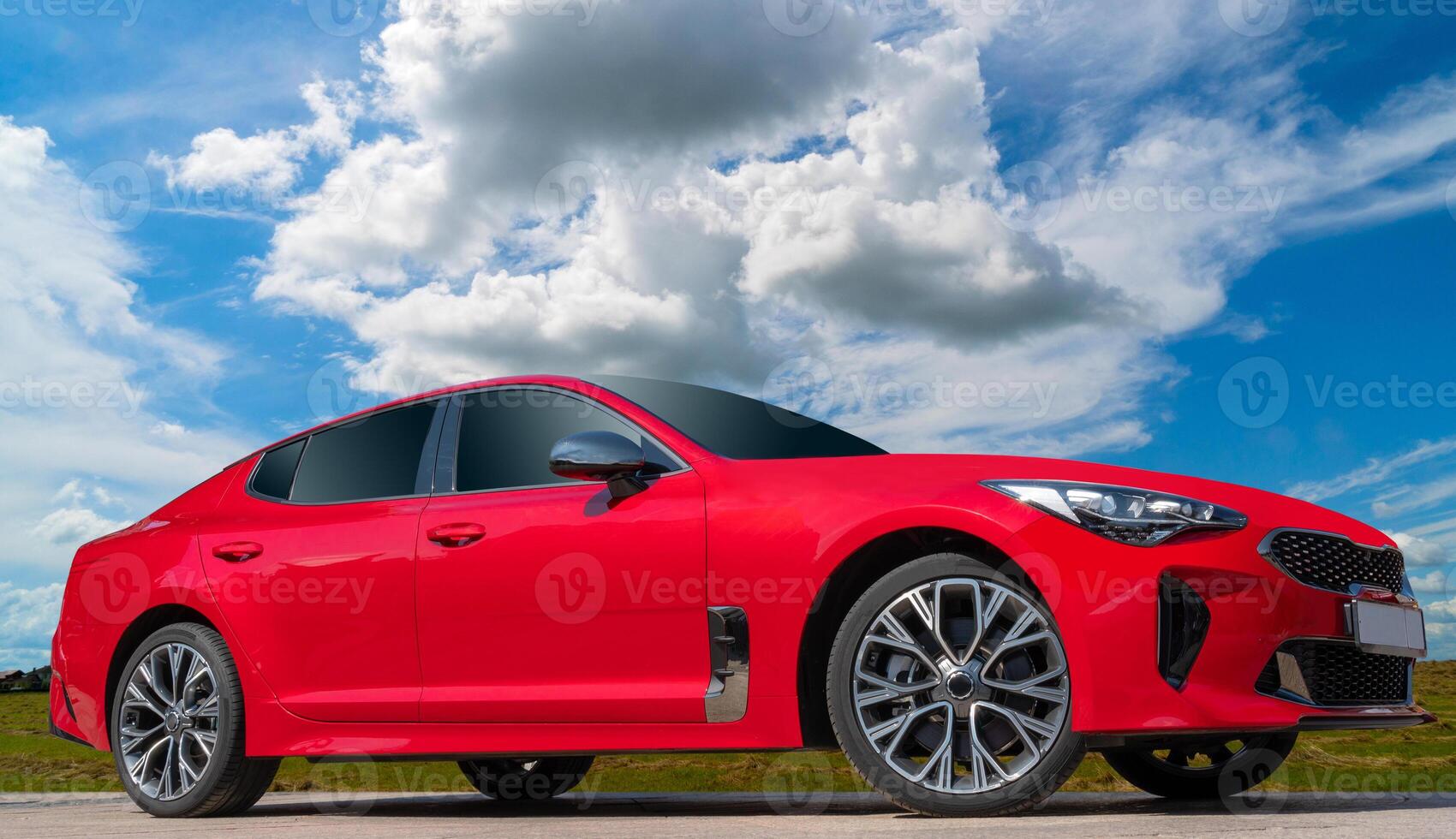 Red car on a blue sky background with white clouds. A stylish, modern, bright image of an avto mobile for design solutions. photo