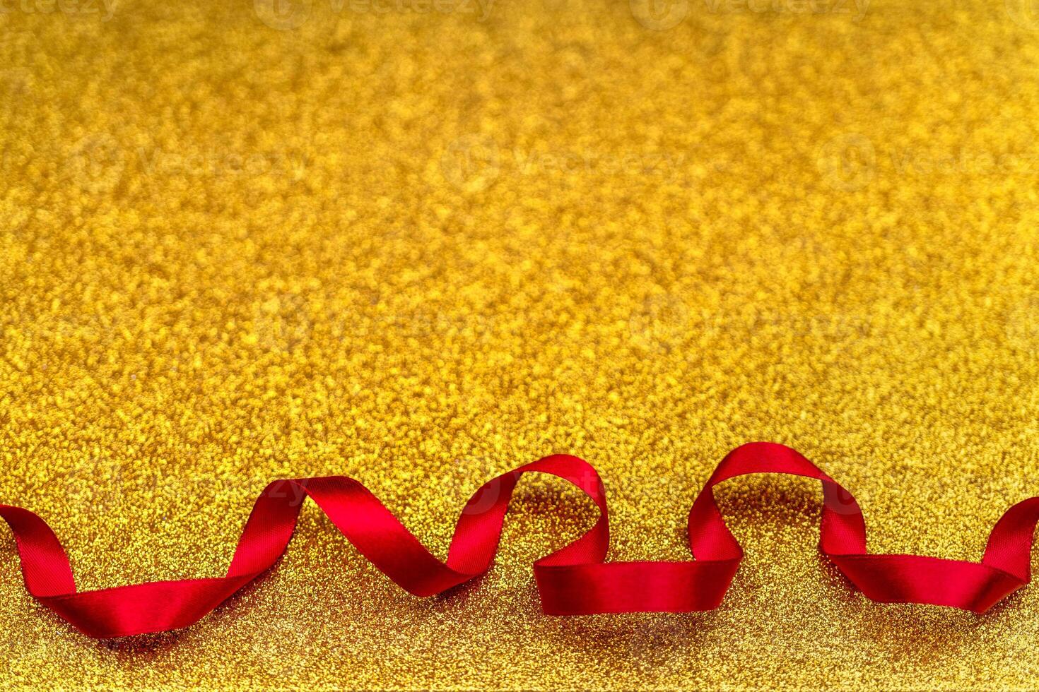 Red wavy ribbon on gold background. Holiday decoration. Valentine's Day decoration congratulation frame. photo