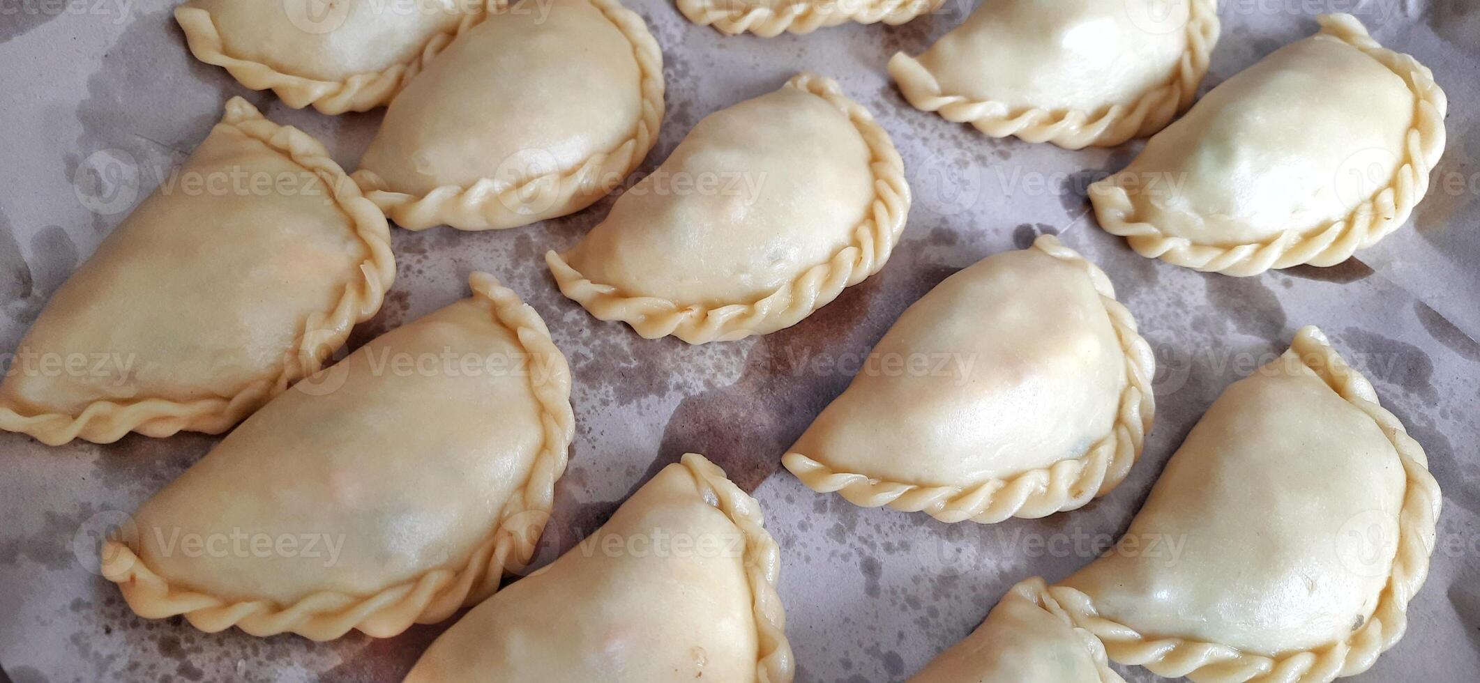 Jalangkote or pastel cake. Preparation for fried. Famous culinary from Makassar South Sulawesi Indonesia. Filled egg, potato, carrot, vegetable served with chili photo