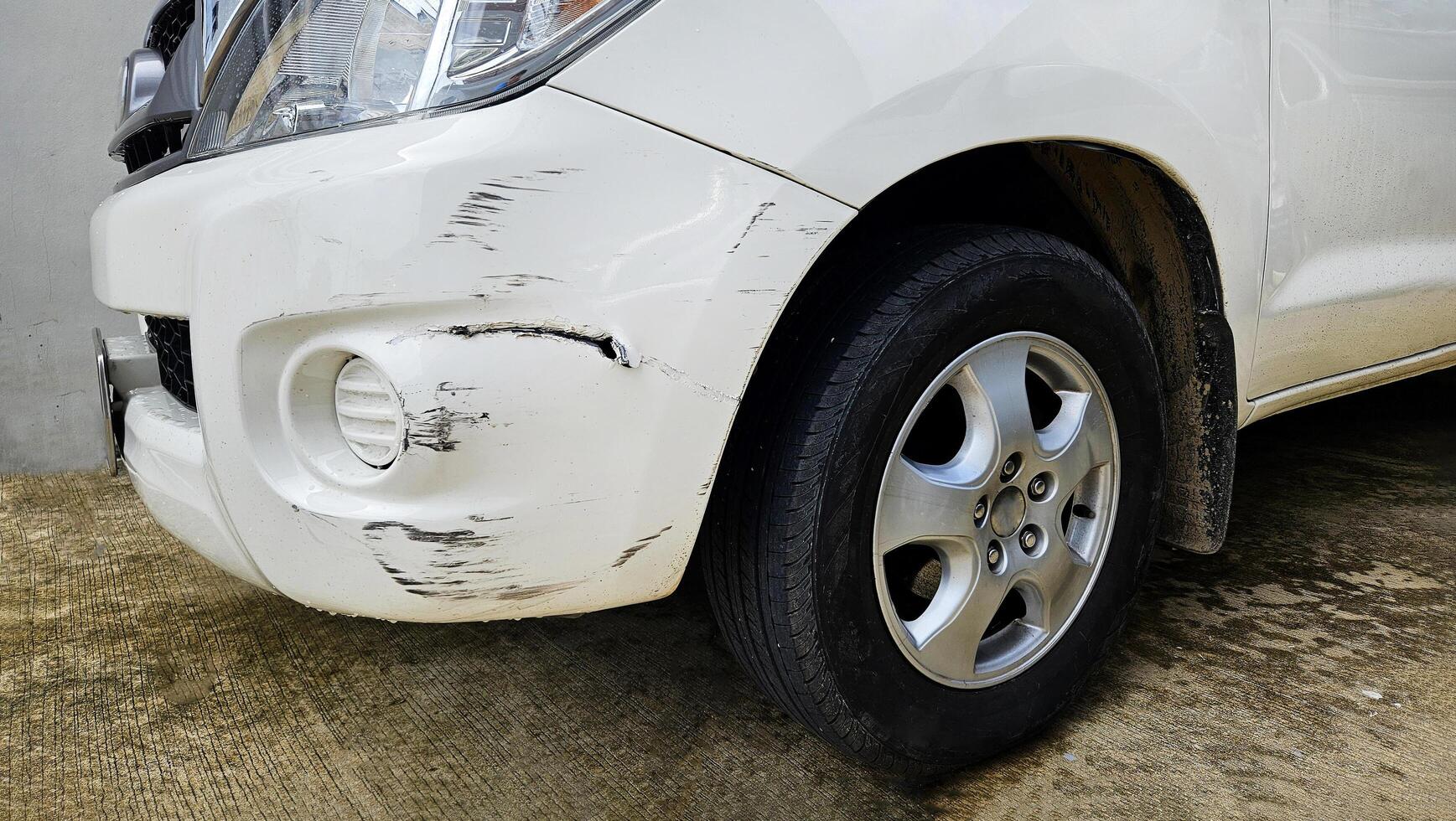 Close up Scratches on white car after accident. Damaged on front bumper with copy space. Insurance of accident or injury, Fix and maintenance concept. photo