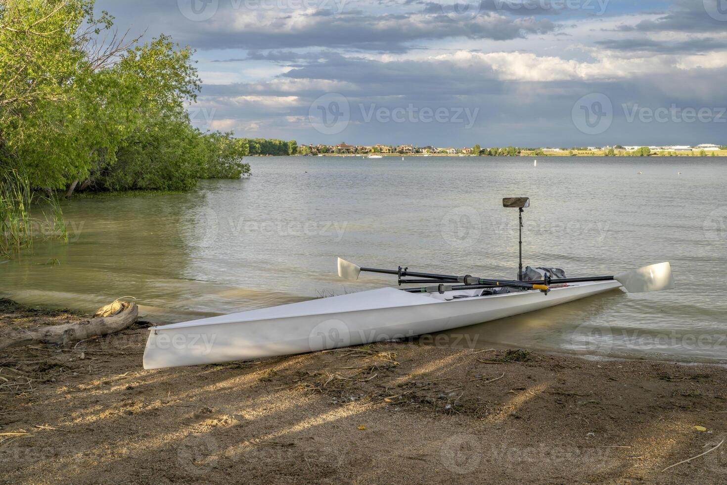 Coastal rowing shell on a shore of Boyd Lake in northern Colorado in late spring or summer scenery. photo
