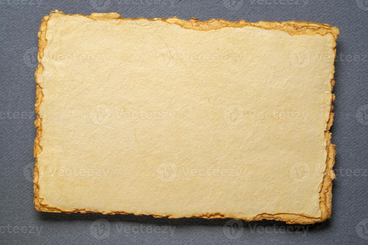 stack of tan toned heavyweight deckle edge paper sheets photo