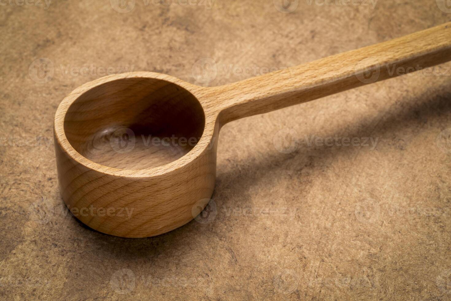 measuring scoop - wooden kitchen cooking utensils on textured bark paper photo