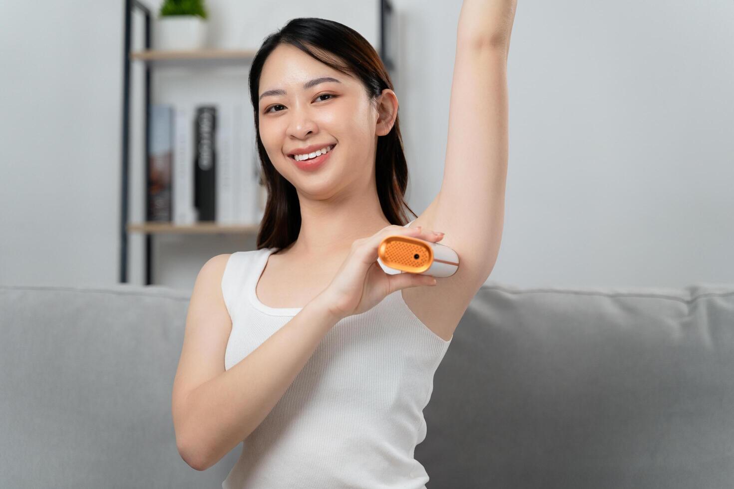A beautiful woman is epilating her armpits using an IPL laser hair removal epilator device photo