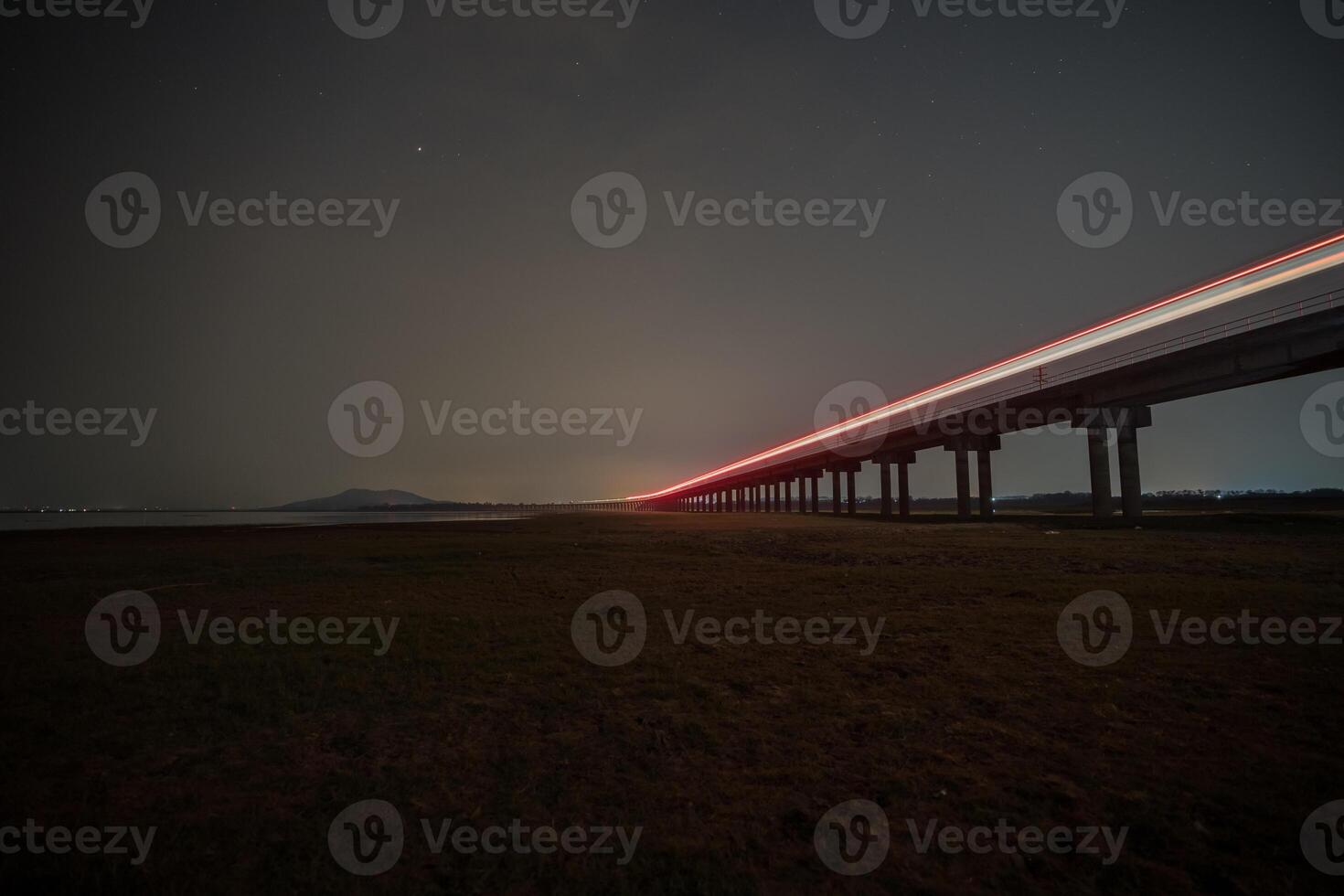 Train is moving on rail at night time with background of star location at thailand photo