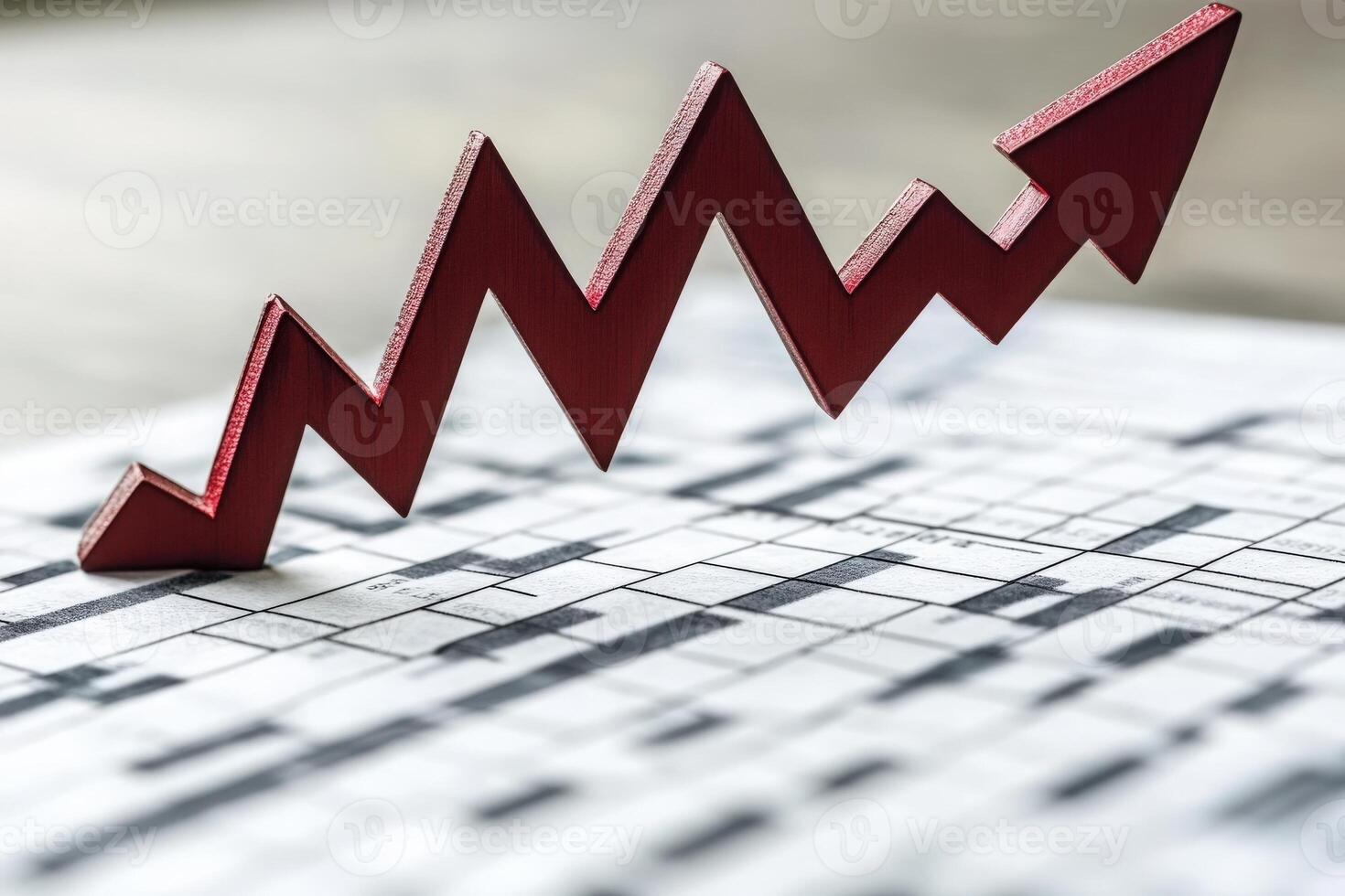 A striking red downward arrow pierces through a printed financial chart, symbolizing a sudden drop in market trends. The chart lies on a wooden table, emphasizing the severity of the decline. photo