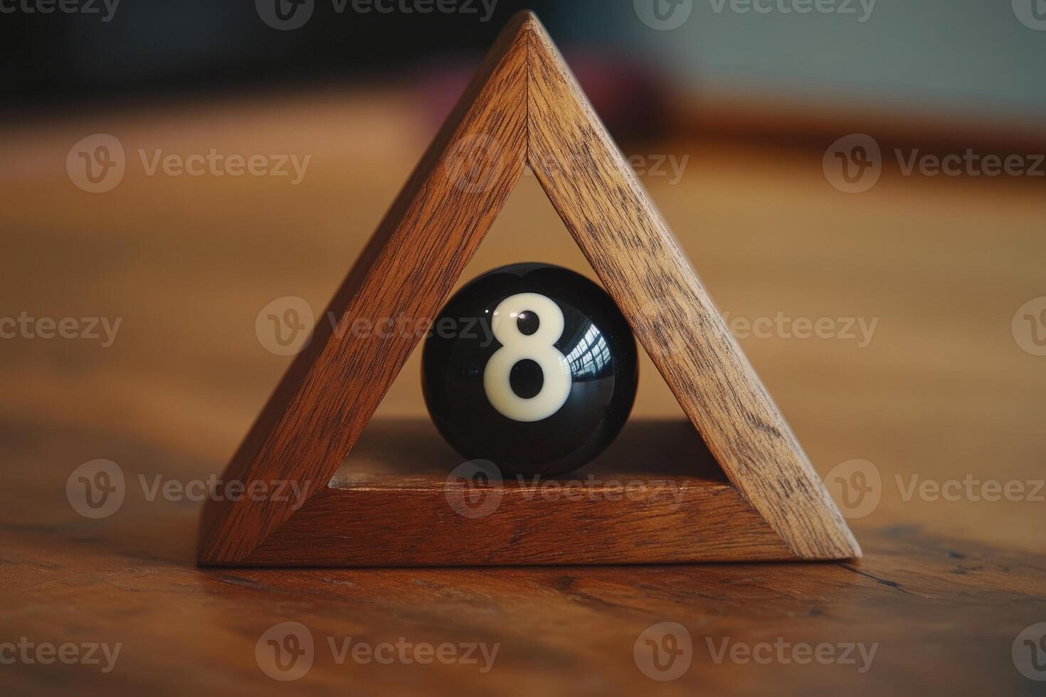 A black snooker ball with the number eight sits alone within a wooden triangle rack on a polished table, creating a quiet moment in a gaming environment. Soft light highlights the scene. photo