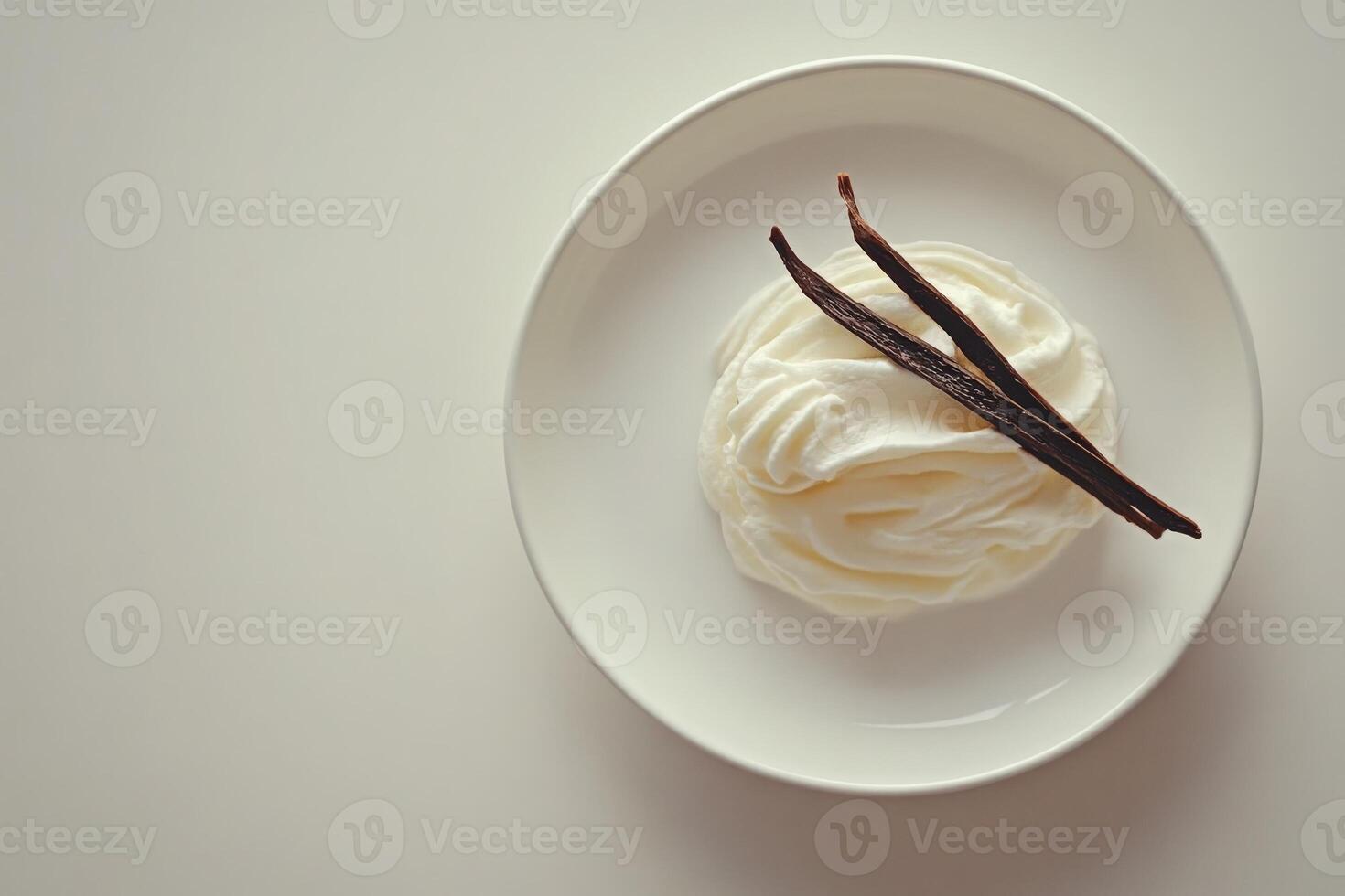 A smooth, creamy mound of vanilla cream rests elegantly on a white plate, enhanced by two dark, aromatic vanilla pods lying atop. The minimalist presentation emphasizes purity and flavor. photo