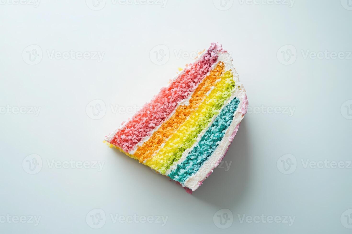 A vibrant slice of rainbow cake features multiple colorful layers arranged in a striking pattern. The slice sits perfectly isolated on a clean surface, highlighting its playful design. photo