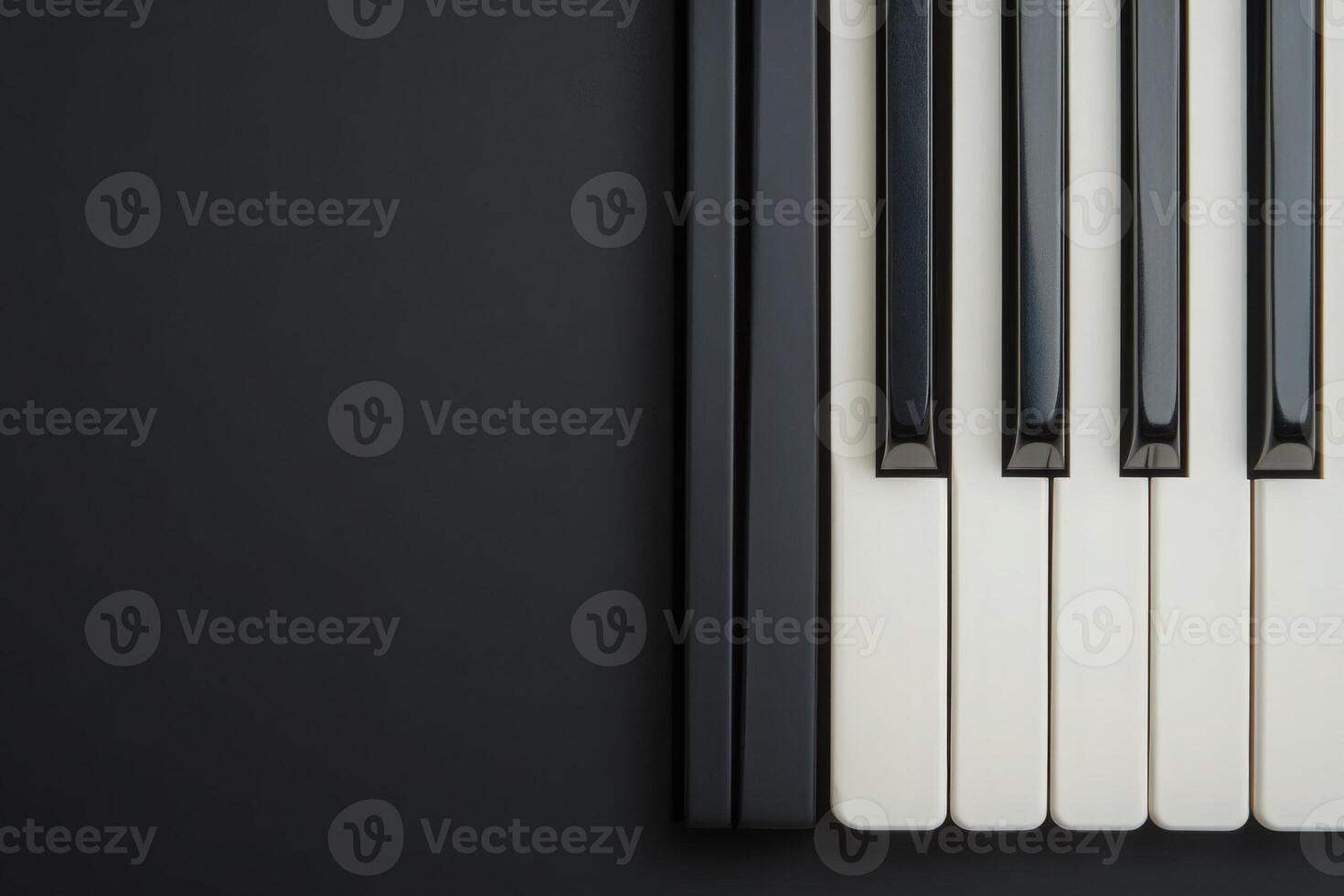 The arrangement showcases black and white piano keys against a solid dark background, emphasizing the elegance and simplicity of the instrument, perfect for musical inspiration and creativity. photo