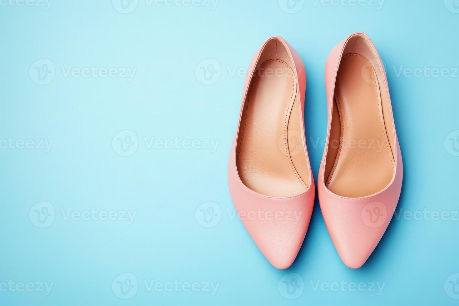 A pair of chic ballet flats rests on a vibrant blue surface, showcasing a modern design ideal for fashionable outfits. The soft pink color adds elegance and versatility for any occasion. photo