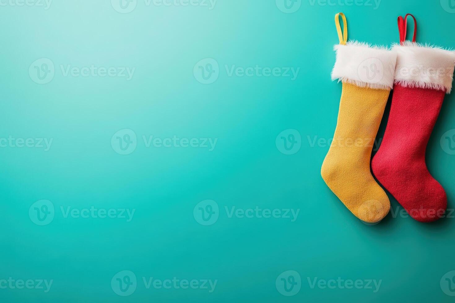 Two vibrant Christmas stockings, one yellow and one red, are neatly displayed against a clean blue background, ready to be filled with holiday treats and surprises for the festive season. photo