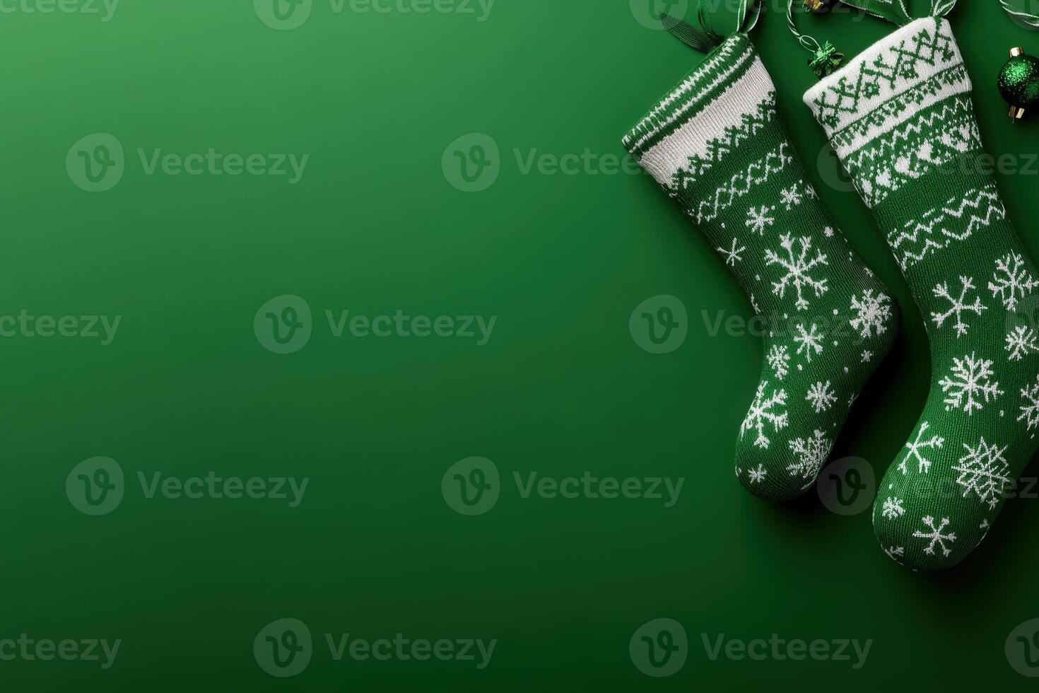 Two green Christmas stockings with white snowflake designs hang against a clean, solid background, adding a festive touch. They are ready to be filled with holiday treats and surprises. photo