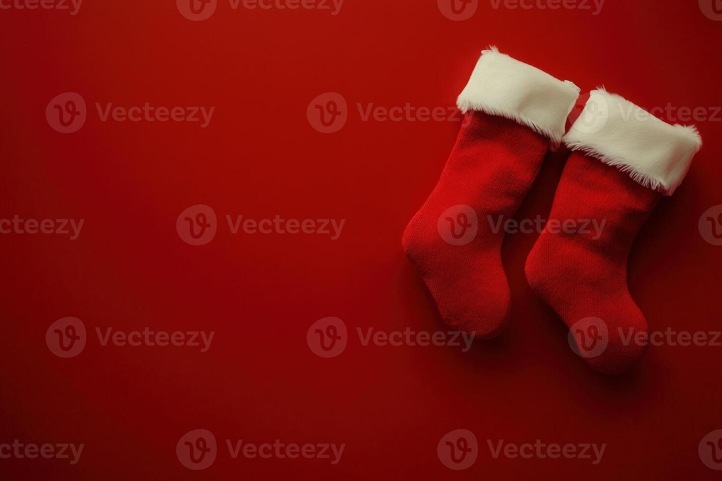 A pair of red Christmas stockings adorned with white fur trim rests against a clean, bright red background, evoking festive holiday cheer and anticipation for seasonal celebrations. photo