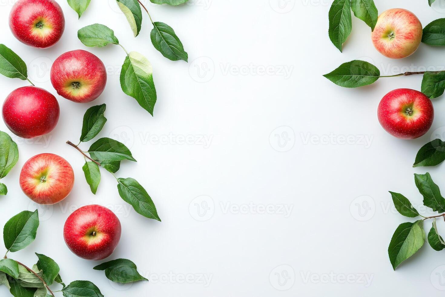 A collection of fresh, red apples is displayed alongside vibrant green leaves against a clean white background. This setup highlights the freshness and natural beauty of the apples. photo