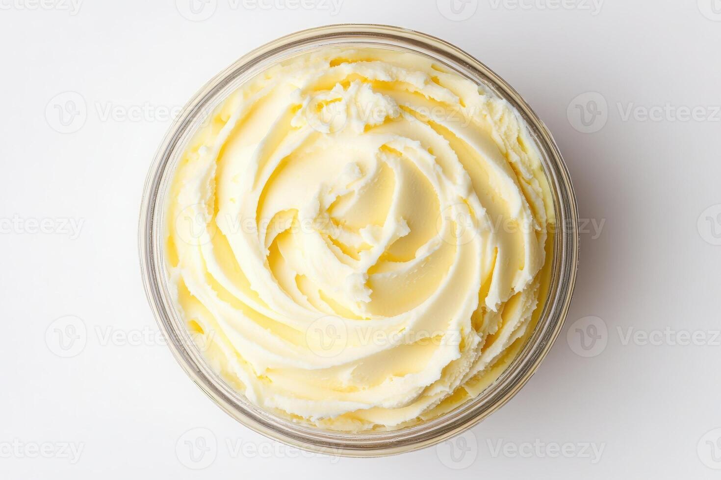 A smooth and creamy texture of heavy cream is displayed in a glass container, presenting a rich, buttery color. This ingredient is commonly used in various recipes and dishes. photo