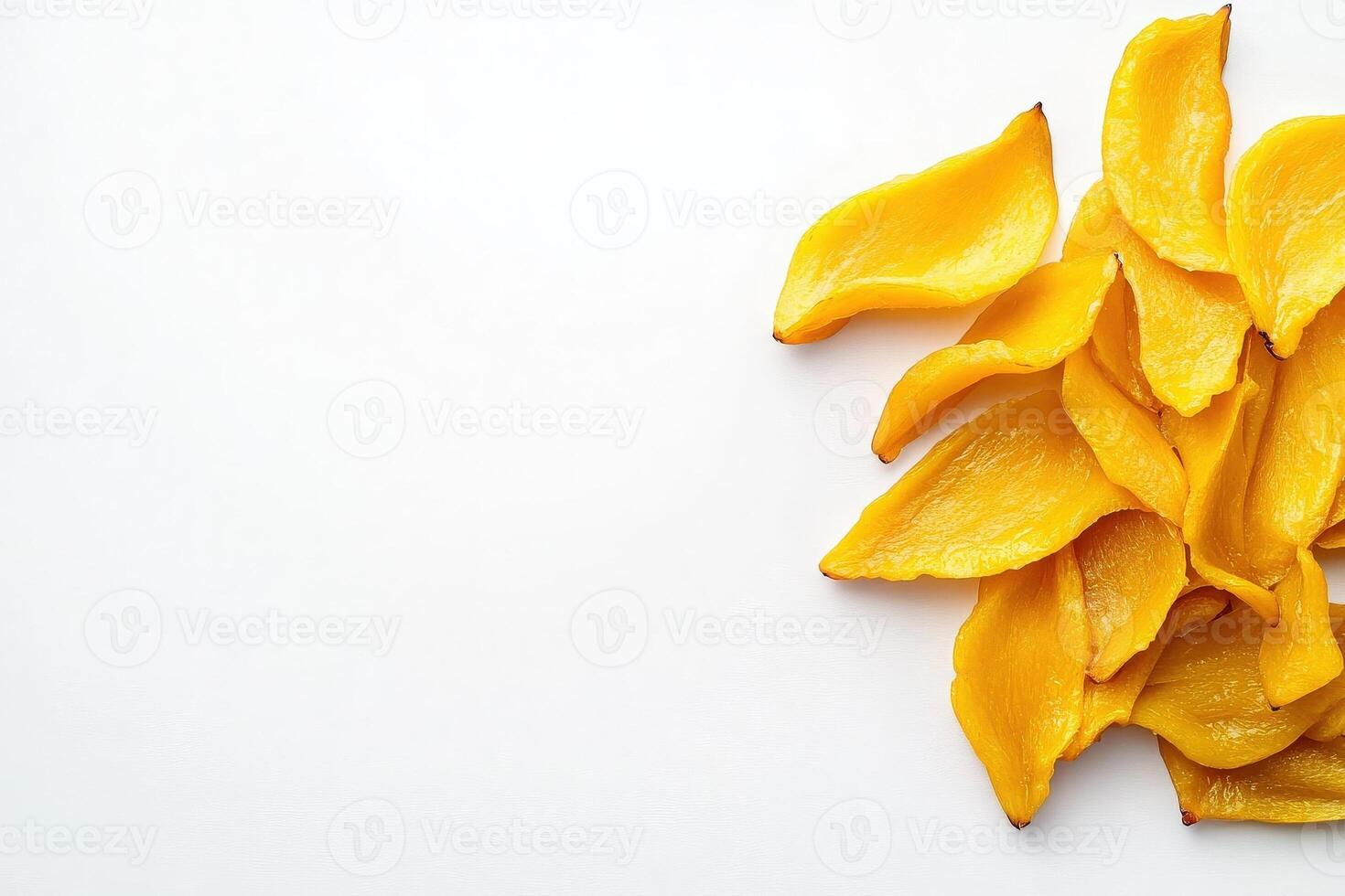 Vividly colored dried mango slices are artfully placed on a pristine white background, emphasizing their natural shape and texture. photo