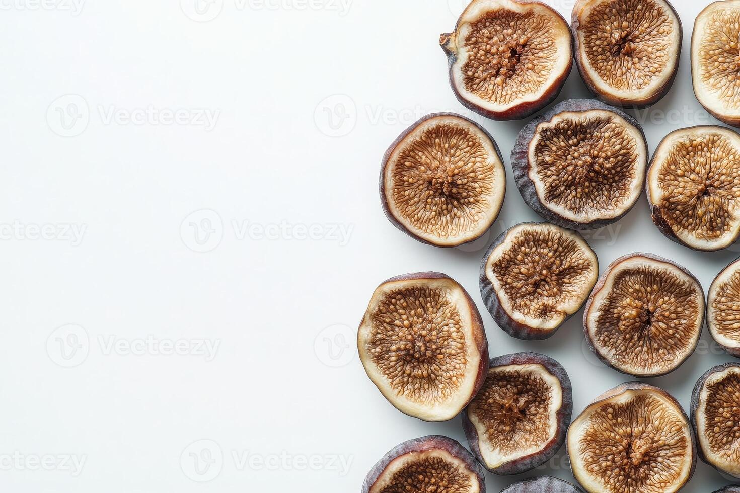 A collection of dried figs laid out on a pristine white surface highlights their rich texture and unique patterns, emphasizing their natural sweetness and health benefits. photo