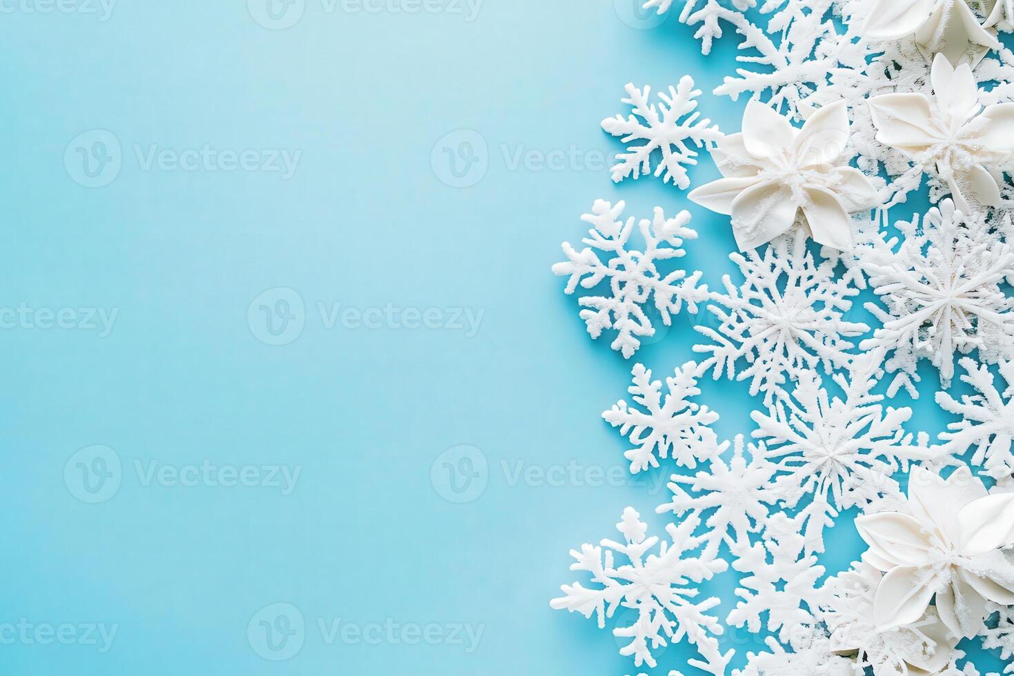 A collection of delicate white snowflakes arranged on a smooth blue surface creates a festive winter atmosphere. This decorative display is perfect for seasonal events and celebrations. photo