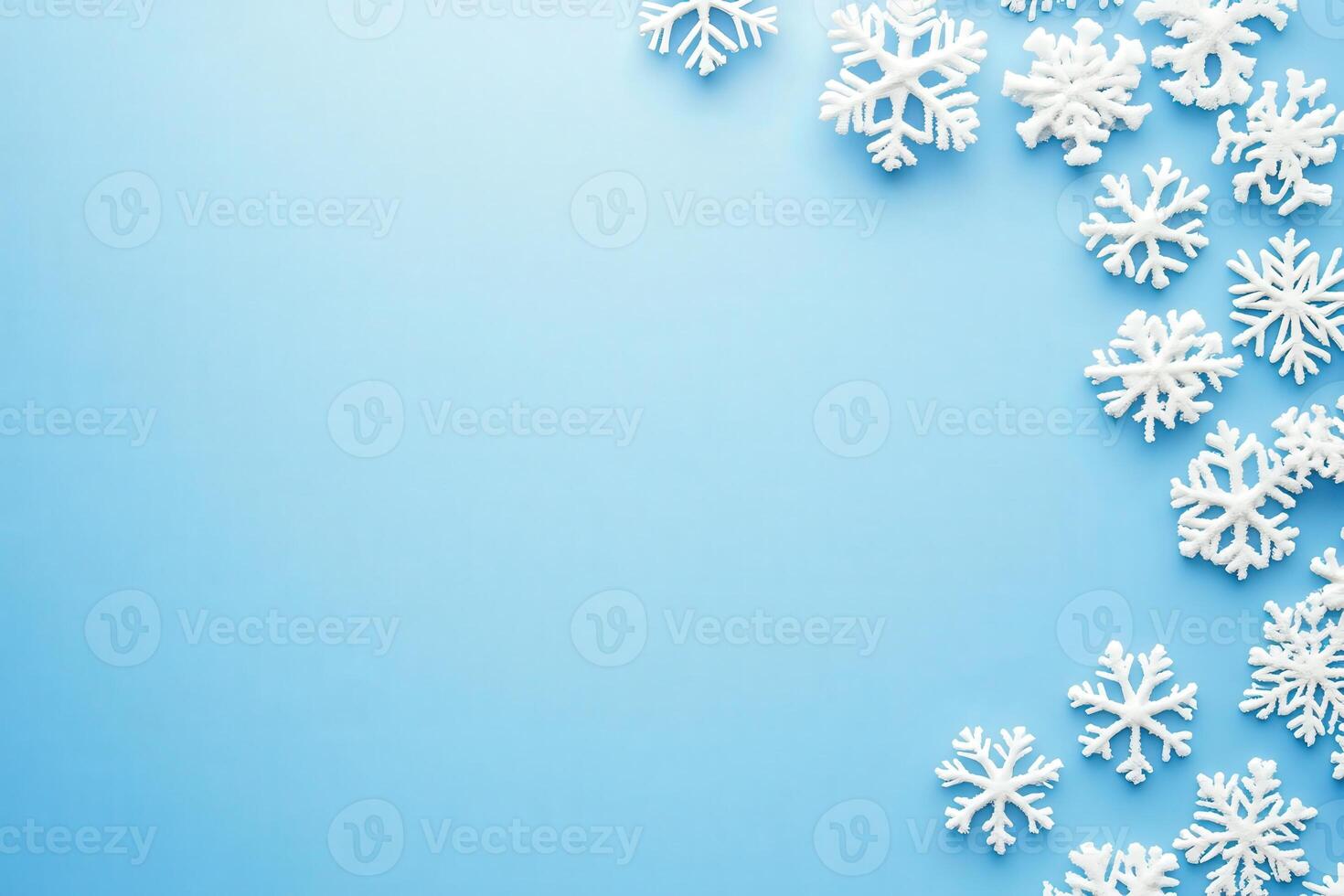Delicate white snowflakes are artfully arranged on a smooth blue background, creating a festive atmosphere perfect for winter themes and holiday decorations. photo