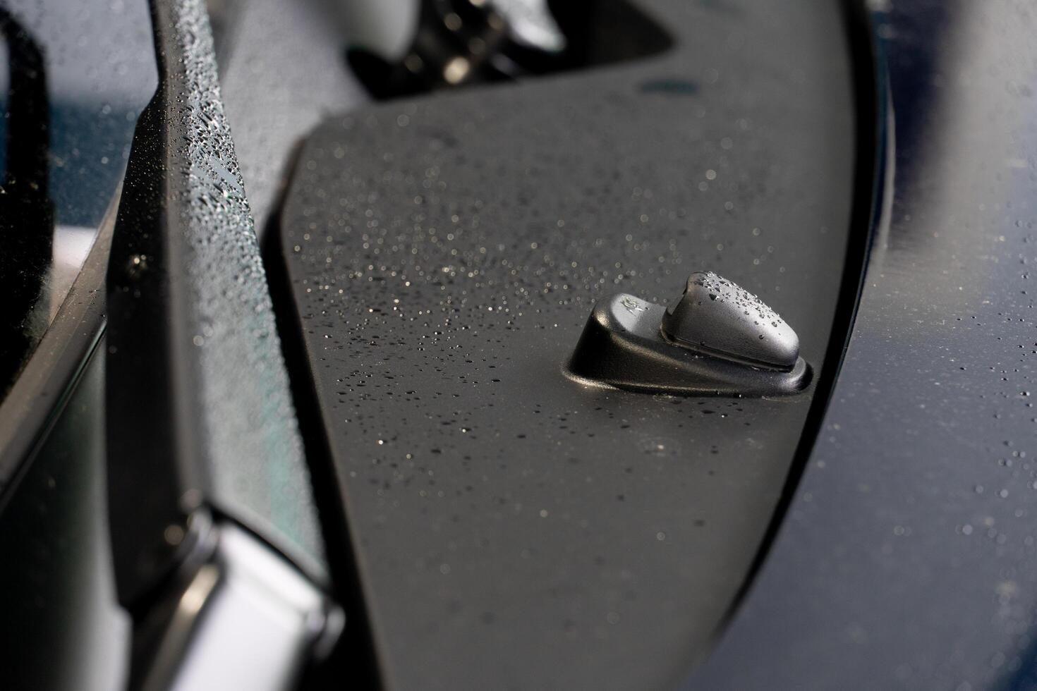 Wiper and Washer of car on plastic body. Blurred illustration of a wet wiper arm and car body. photo