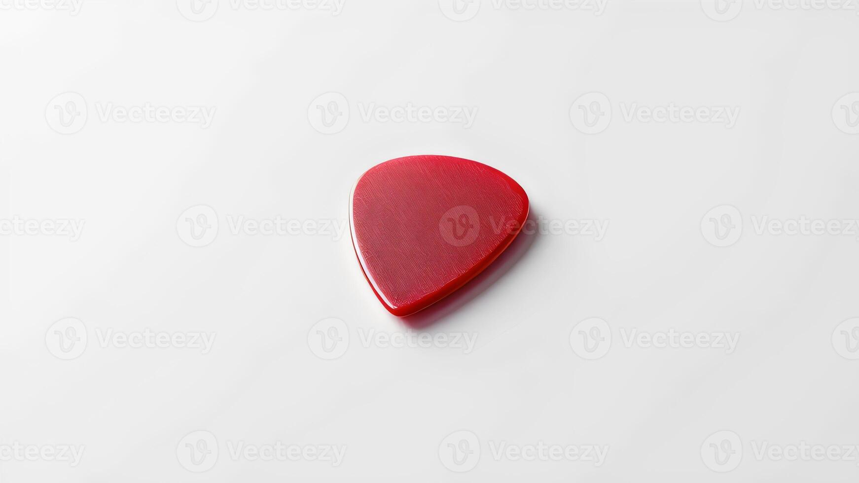 A red guitar pick on a white surface for music and instrument branding photo