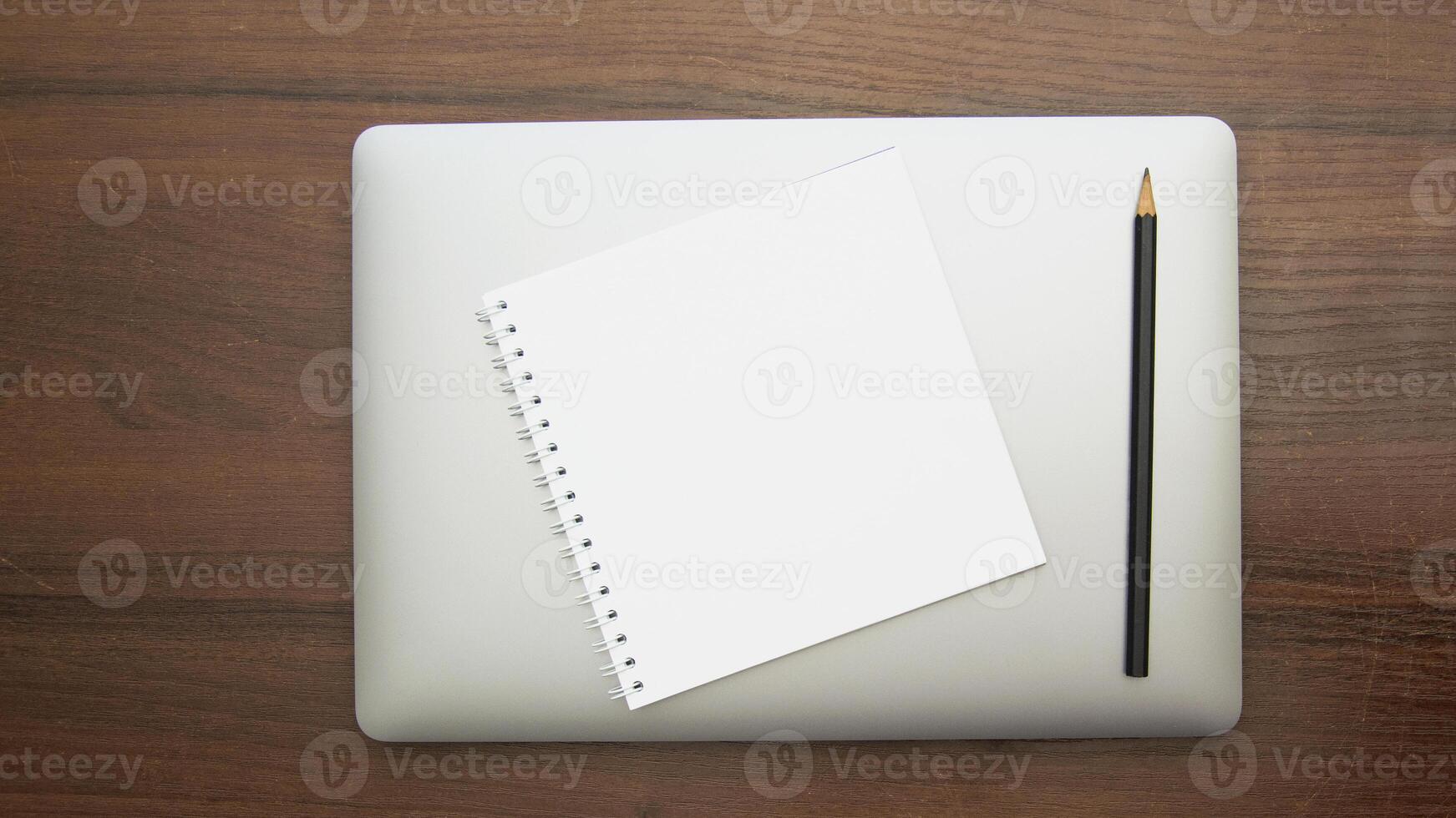 Blank notebook and pencil on laptop stock photo