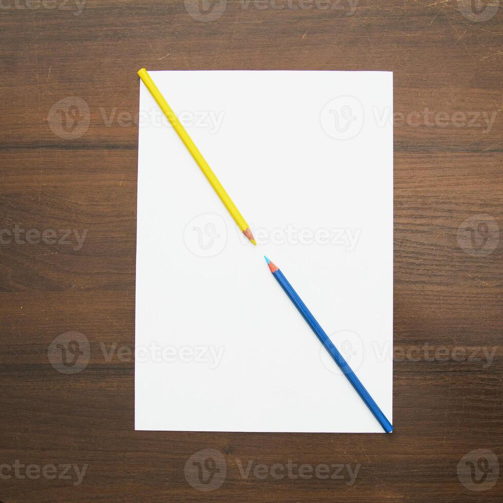 A white sheet with two pencils on top of it photo