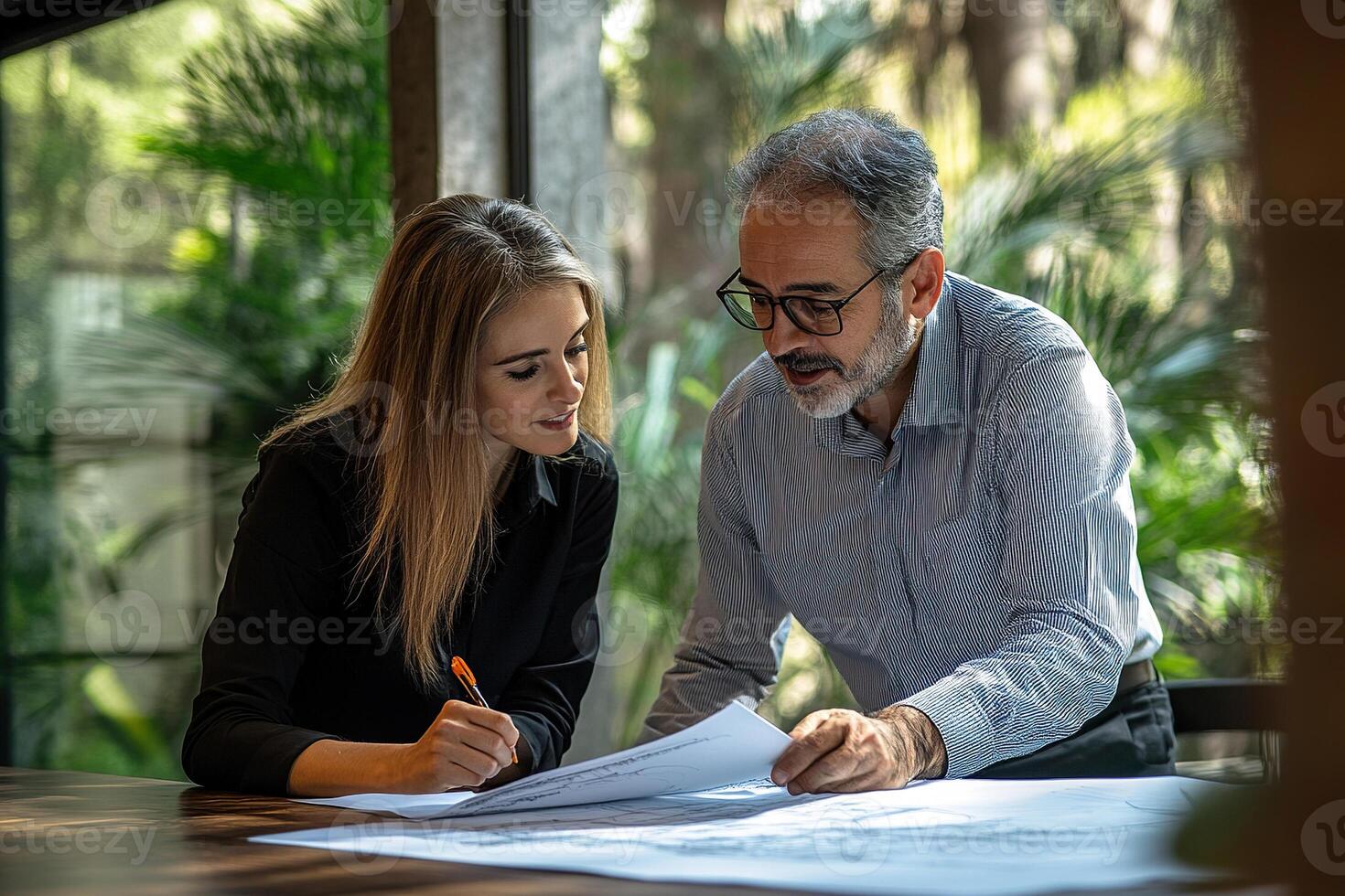 Man and woman discussing project at table in office. Middle aged office worker concept. photo