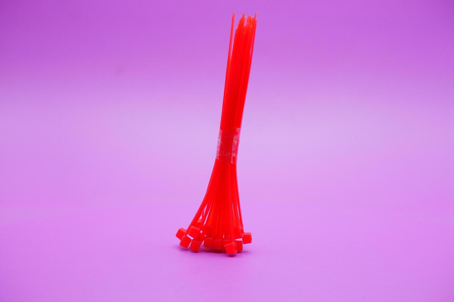 bundle of red zip ties isolated on purple background. Cable ties or cable ties, straps that can be used for various purposes. photo