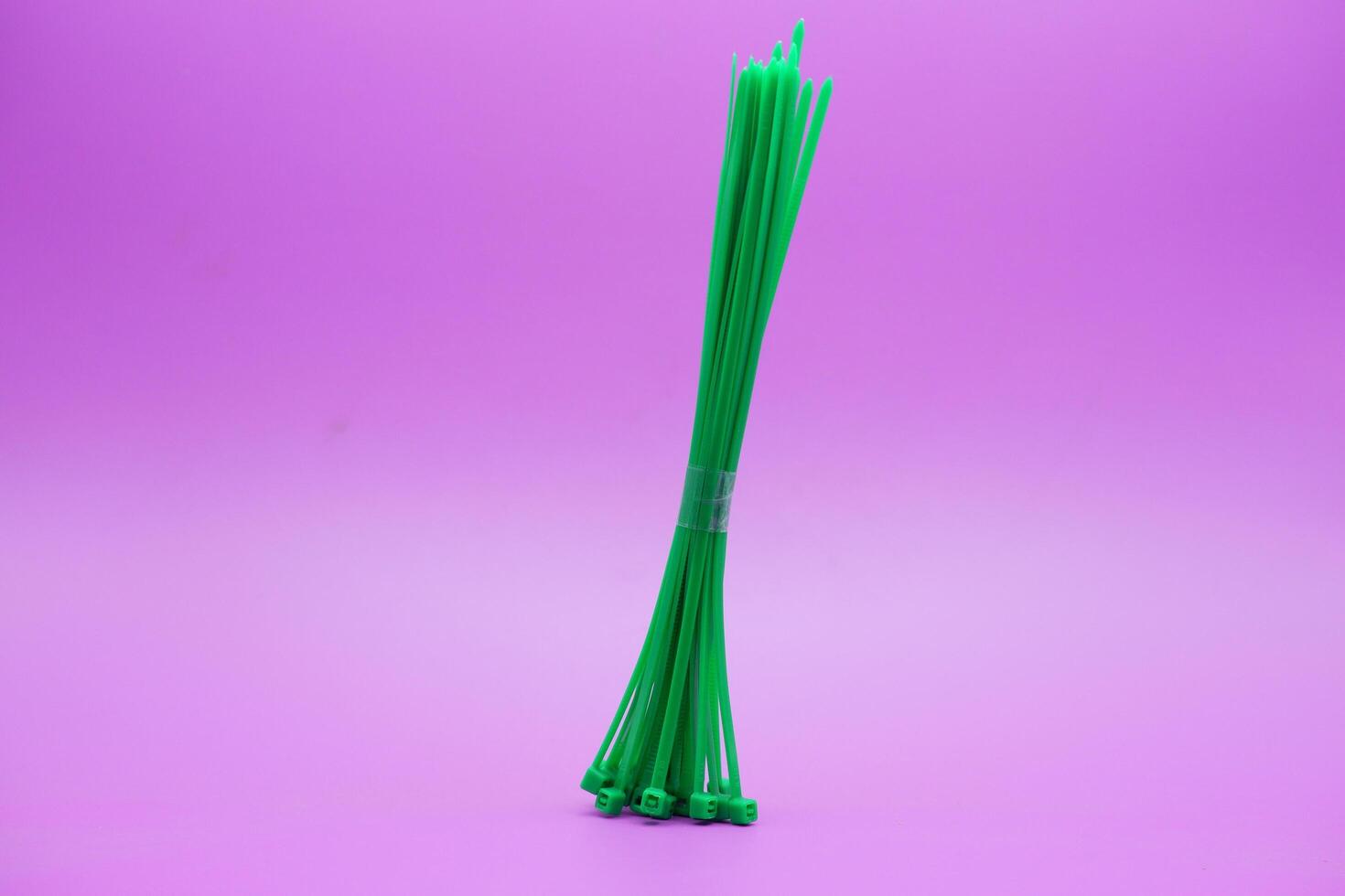 bundle of green zip ties isolated on purple background. Cable ties or cable ties, straps that can be used for various purposes. photo